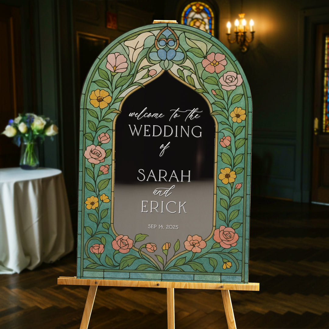 Decorative wedding sign with floral arch design in a room with a table and flowers. Custom wildflowers stained glass wedding sign.