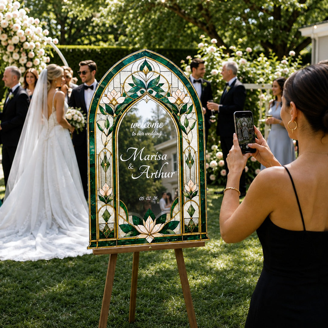 Wedding ceremony with a decorative sign and guests taking photos. Emerald Green Stained Glass Arch Wedding Welcome Sign. Faux stained glass wedding sign, fully customizable silver mirror acrylic.
