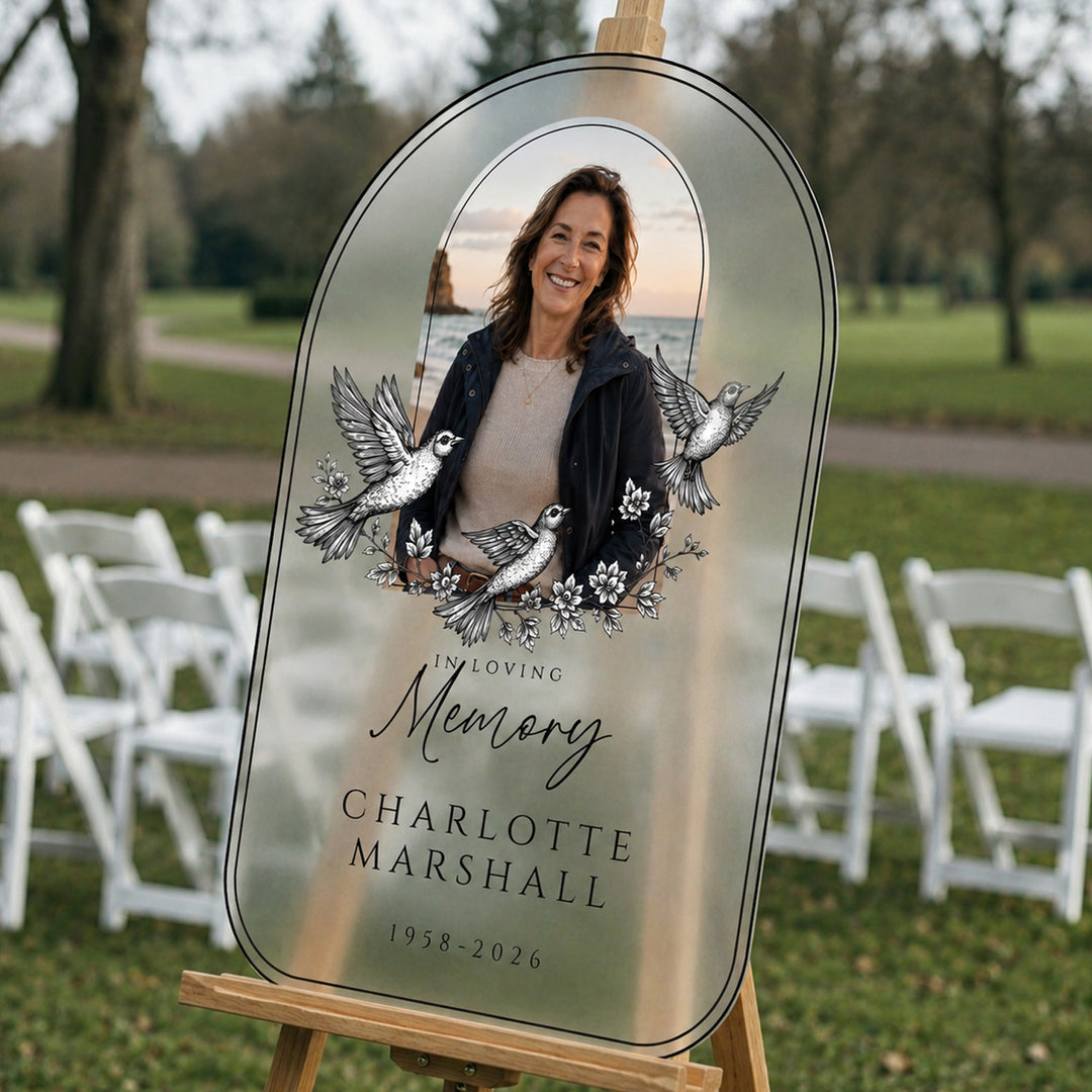 Memorial plaque with a woman's photo and text in a park setting. In Loving Memory funeral custom sign.