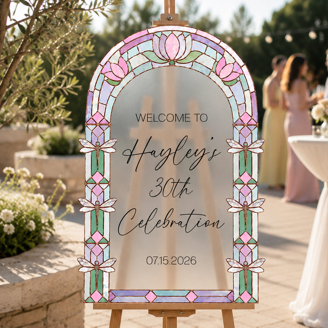 Lotus dragonfly stained glass birthday celebration welcome sign on easel at garden party.